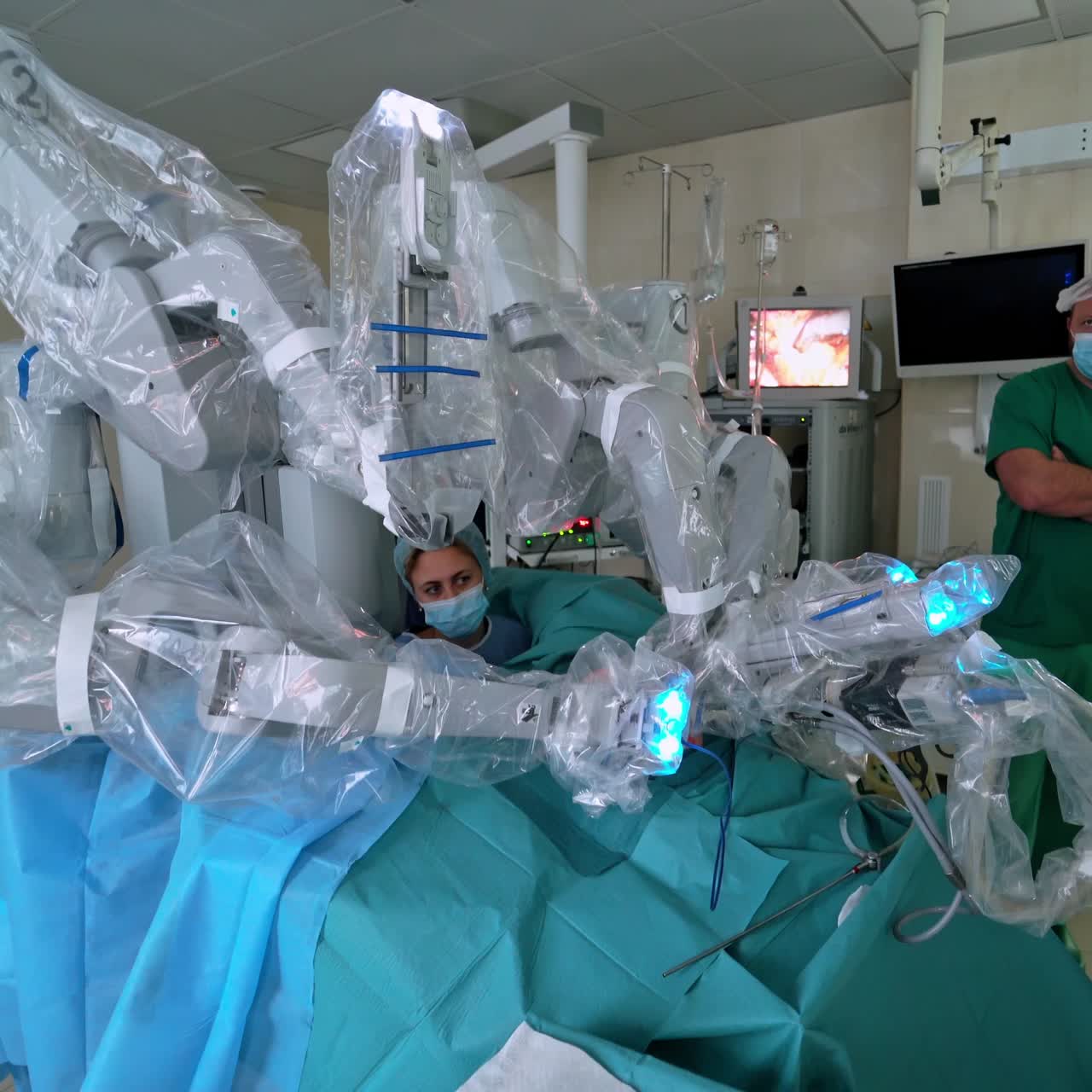 Medical operation involving robot. Group of doctors in mask observe the robotic surgery on monitor. Future medicine.