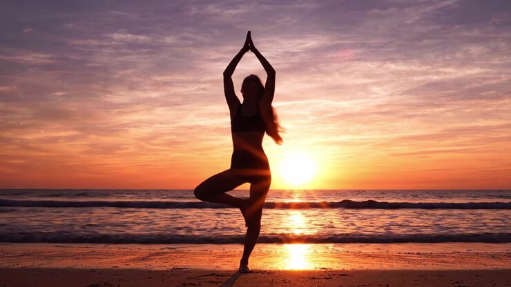 Una serena práctica de yoga al atardecer en la playa: Abrazando la tranquilidad y la conexión con la naturaleza a través del movimiento y la quietud a lo largo de la orilla.