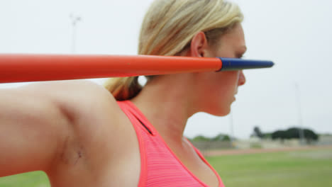 close-up of caucasian female athlete practicing javelin throw at sports venue 4k