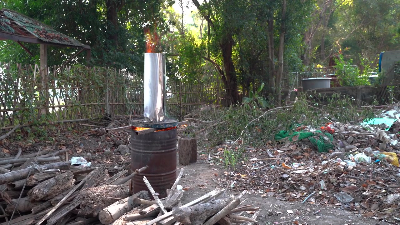 Actieve brandton met open vlam, afval en houtstapels, dolly links, in Chiang Mai, Thailand
