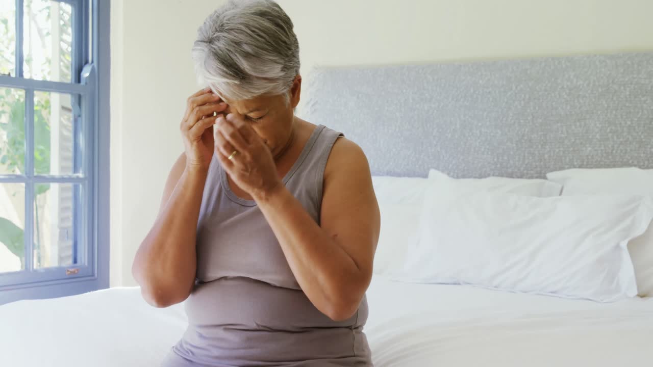 mujer mayor con dolor de cabeza en la cama en el dormitorio 4k