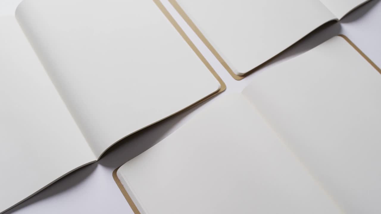 Close up of open blank books with copy space on white background in slow motion