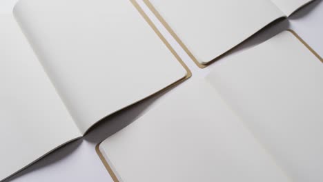 close up of open blank books with copy space on white background in slow motion