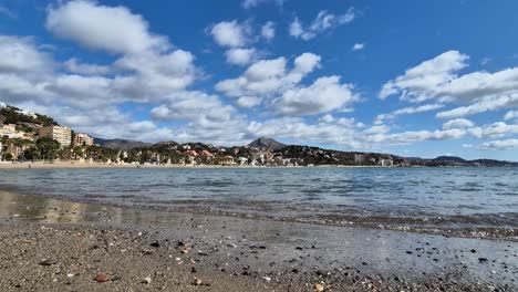 La-Malagueta-Beach-on-a-Sunny-Day-with-waves-Slowly-Breaking-on-the-Shoreline,-Spain