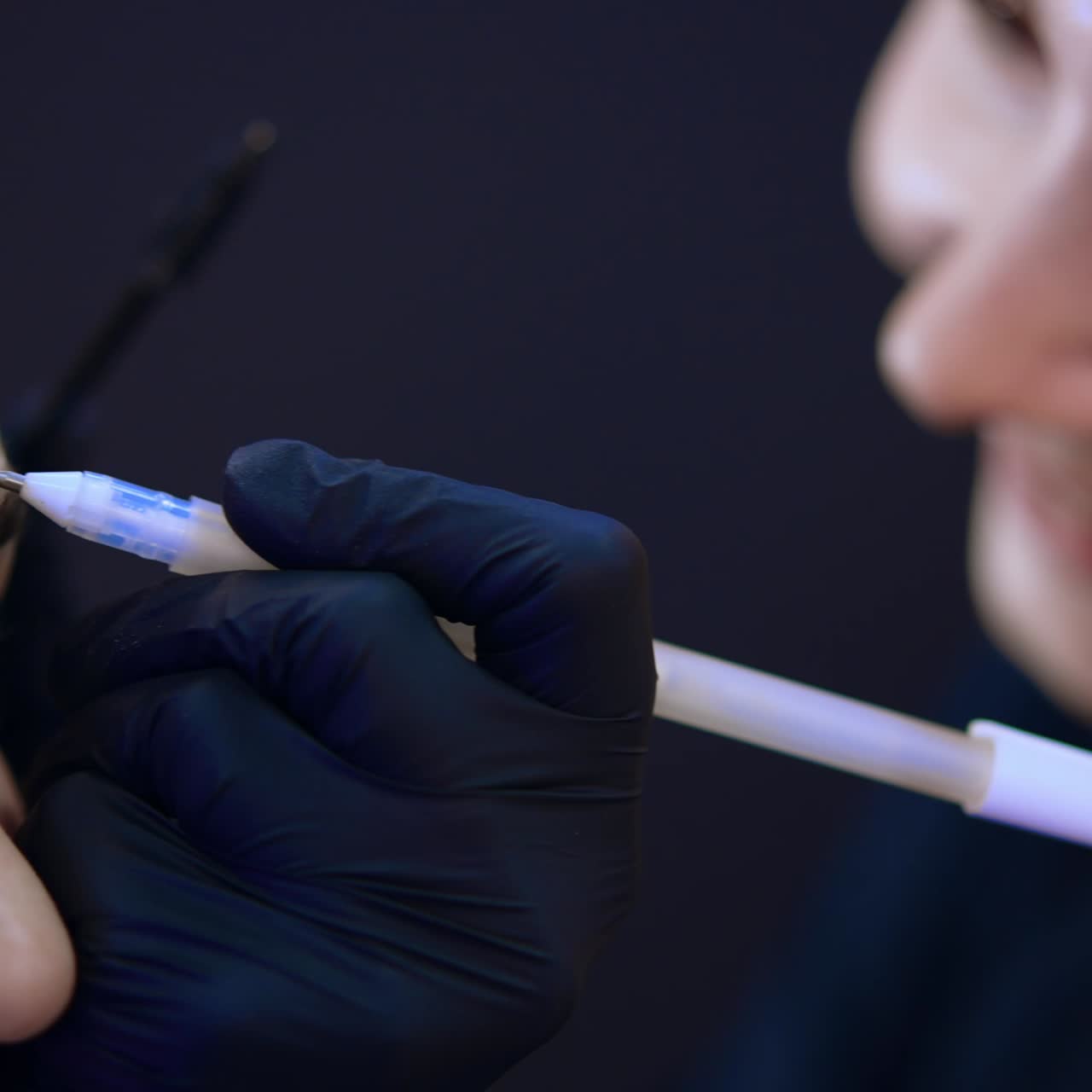 Estetista caucasica che disegna una linea sopra il sopracciglio. Microblading, flusso di lavoro di micropigmentazione delle sopracciglia in un salone di bellezza. Primo piano estremo