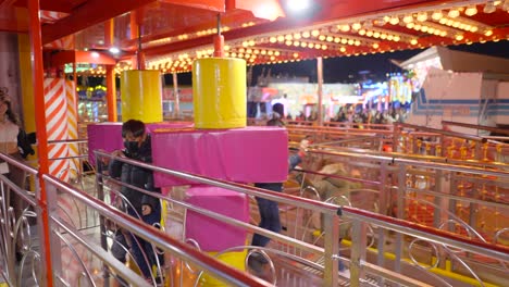 children enjoying a ride at a funfair at night