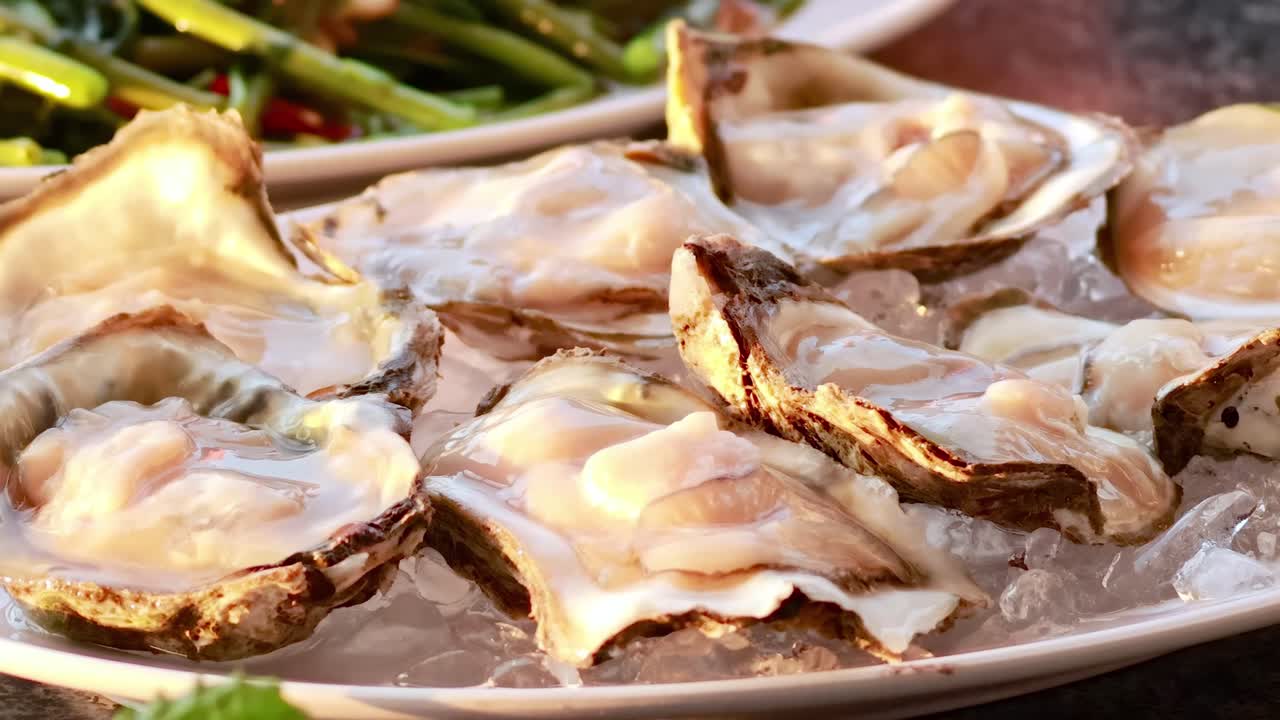 Close-up view of fresh oysters and stir-fried greens being served and enjoyed.