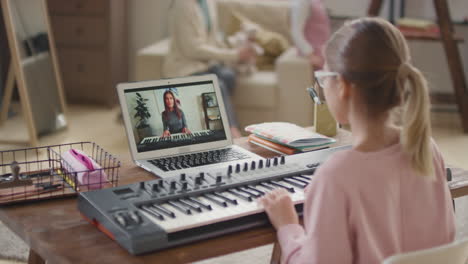 girl taking online piano lesson