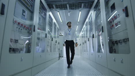 engineer walking through a power plant control room