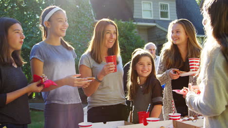 family and friends talk and eat at a block party