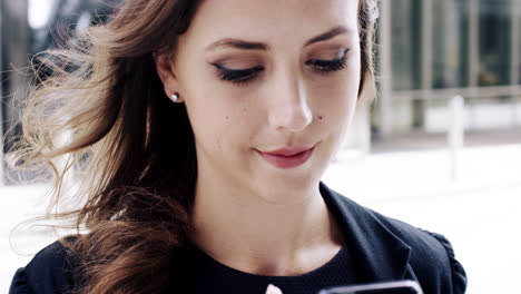 Attractive-business-woman-commuter-using-smartphone-in-city-of-london