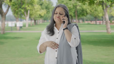 Indian-mother-talking-on-phone-in-park