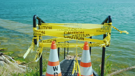 flooded pier entrance with warning tape