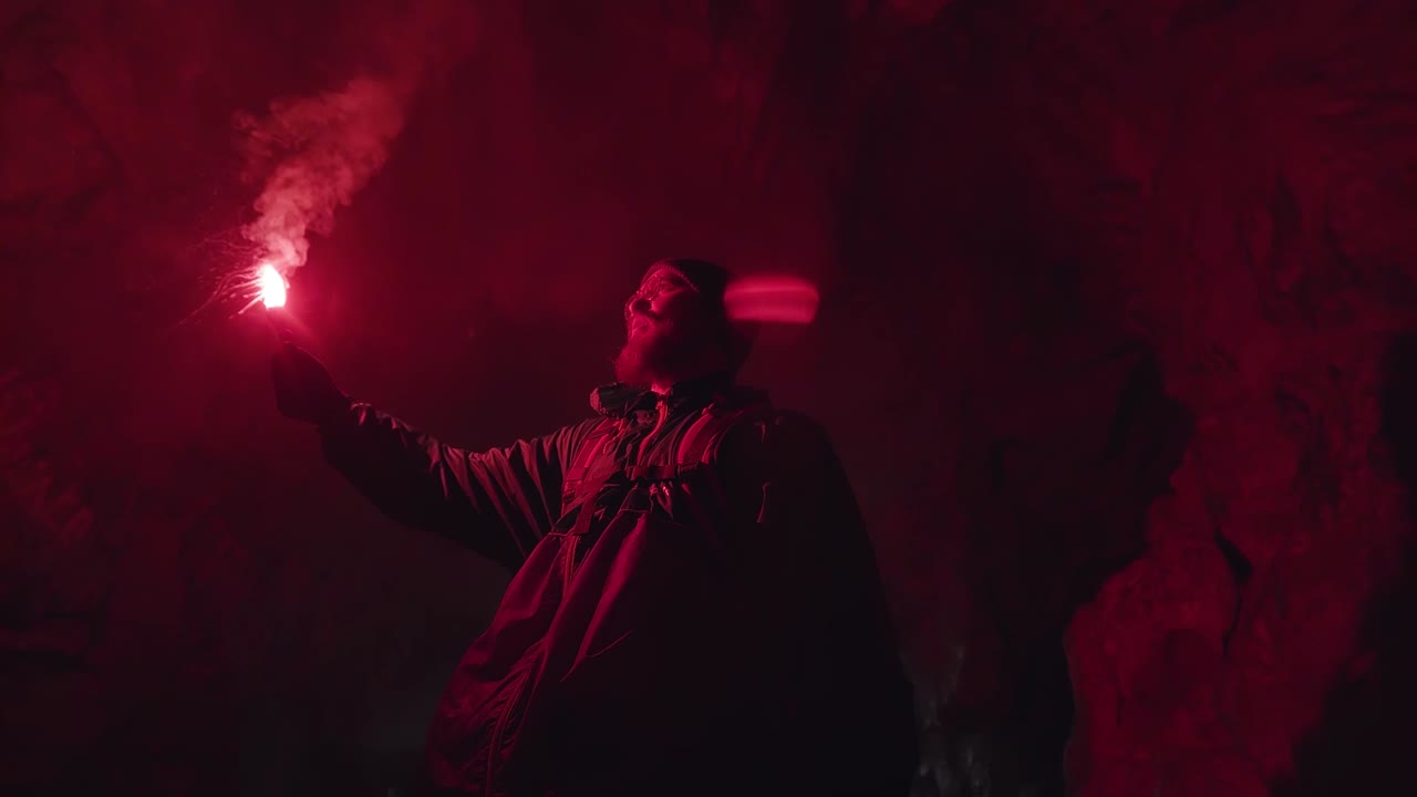 exploración de la cueva por la noche con llamarada roja