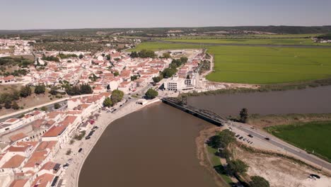 Aerial-birds-eye-view-of-rice-paddy-fields-and-traffic-crossing-bridge-toward-parish-town