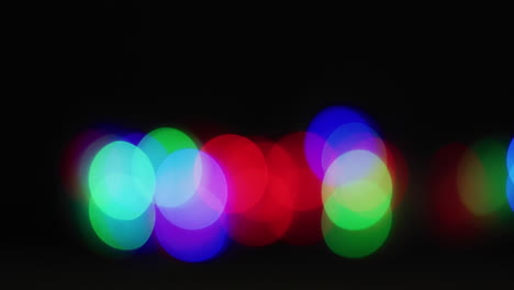 multiple multicoloured lights flickering on black background