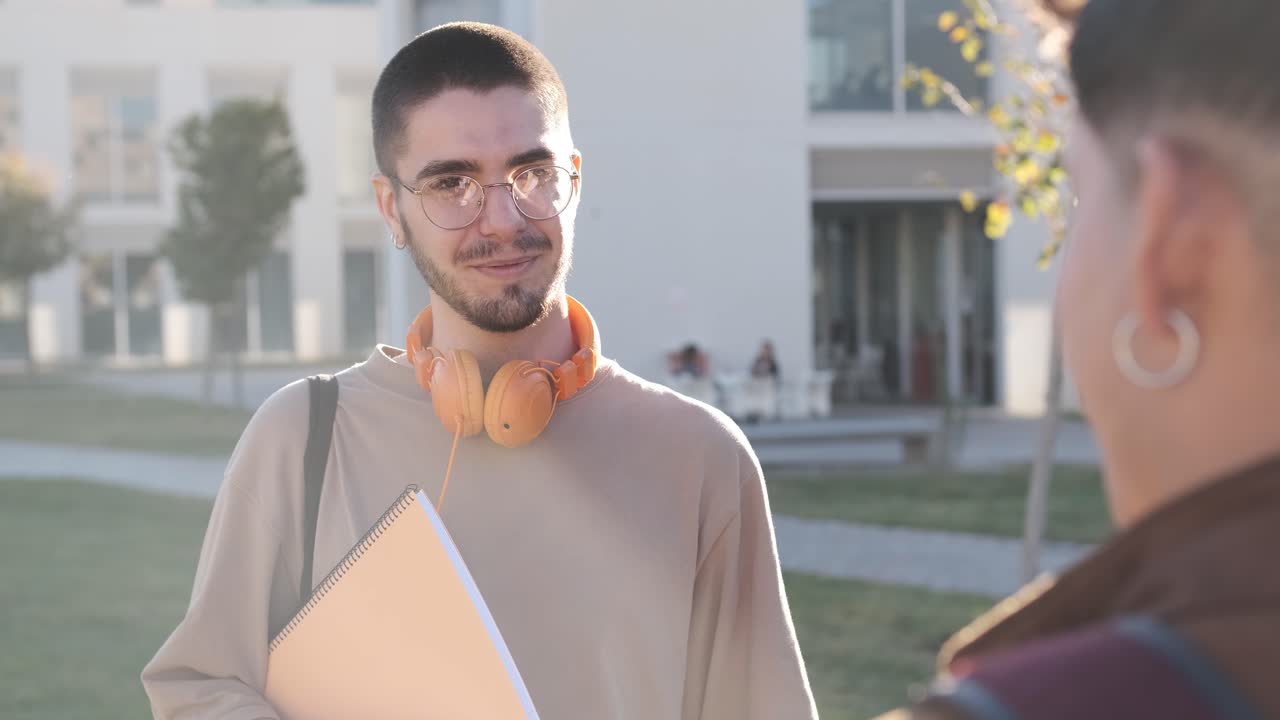 Focus on a caucasian student talking with a friend outside the university