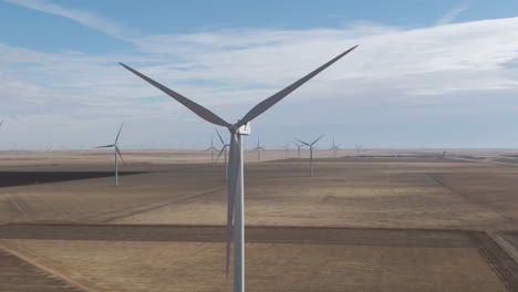 4k close up of large wind turbine spinning over plains in north texas, usa amid a mass wind farm