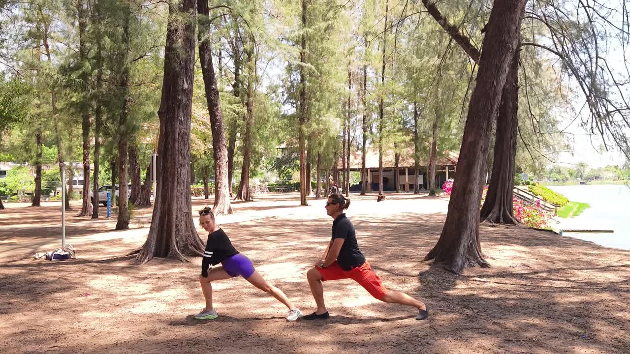 una pareja estirándose en un parque.