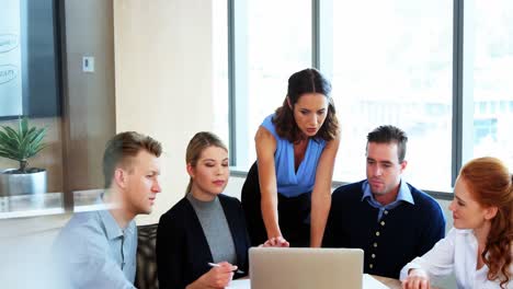 Executives-discussing-over-laptop