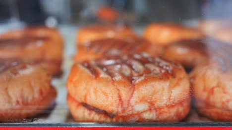 close-up of delicious glazed donuts in a bakery display case