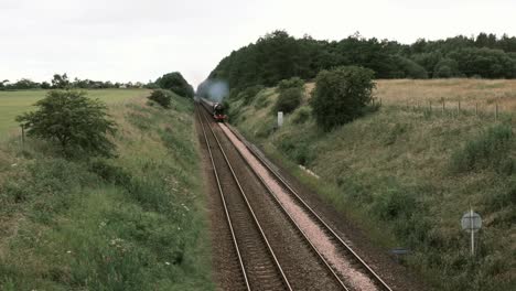 The-Flying-Scotsman,-classic-steam-locomotive,-travelling-through-the-Scottish-countryside-on-an-overcast-day-in-Aberdeenshire,-Scotland,-UK