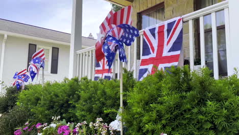 closeup on patriotic lawn ornament spinning in the front yard of a house with british flags hanging on the porch