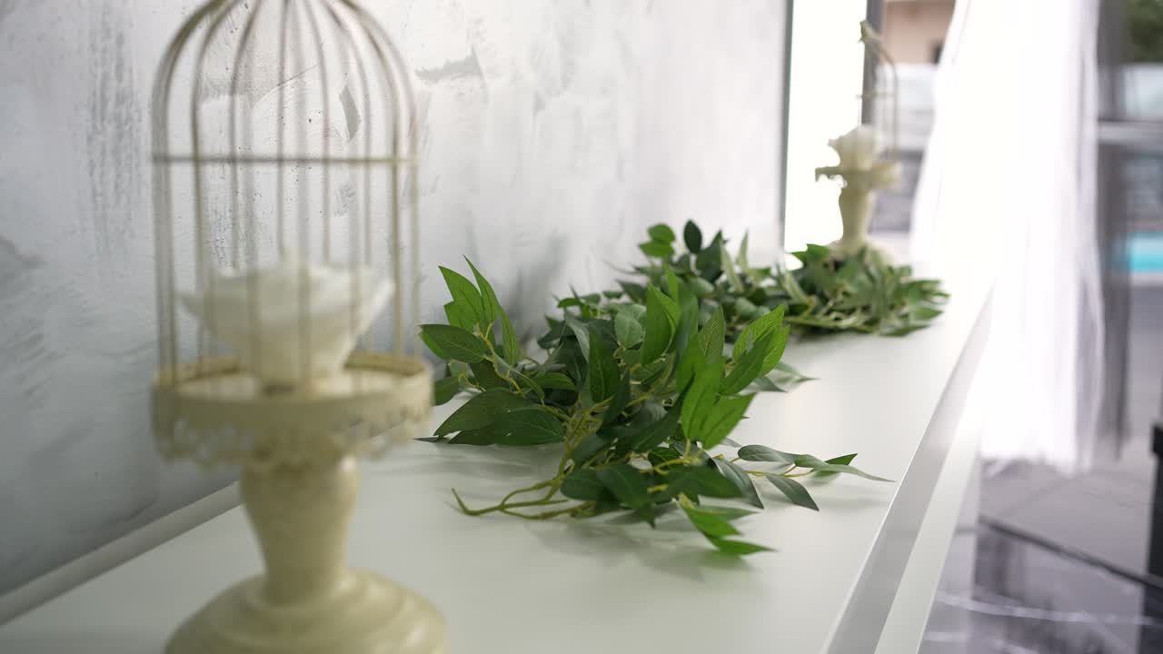 Elegant display of a white rose in a decorative cage on a minimalistic table