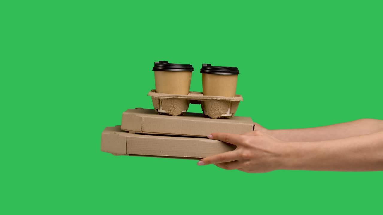 피자와 종이 컵 세트와 커피를 담은 두 개의 카드보드 상자를 제공하는 여성 손. 녹색 화면 크로마 키. 피자와 음료의 클로즈업. 음식과 음료의 빠른 택배 배달. 느린 모션.
