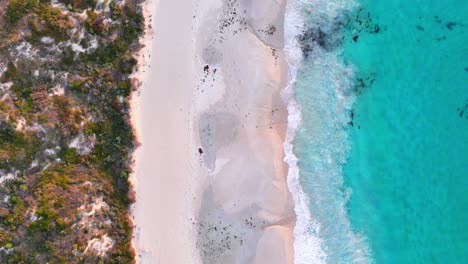 Top-down-drone-view-of-surf-in-Margaret-River,-Western-Australia-at-sunset