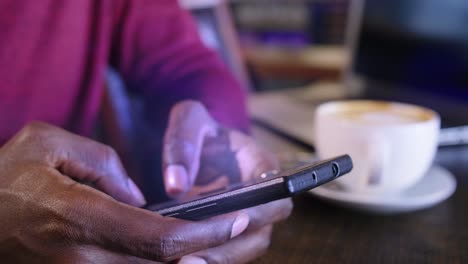 person using smartphone in a coffee shop