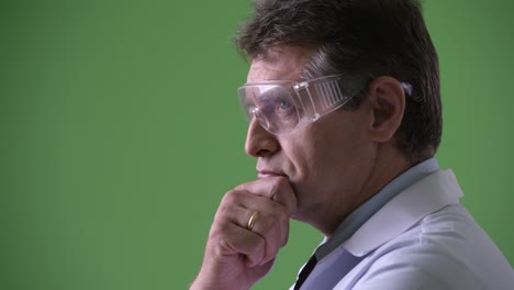 mature handsome man doctor against green background