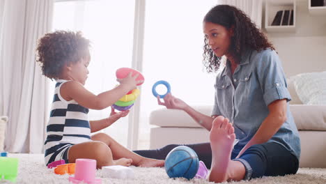 Una-Joven-Negra-Y-Su-Hija-Jugando-Con-Anillos-De-Plástico.