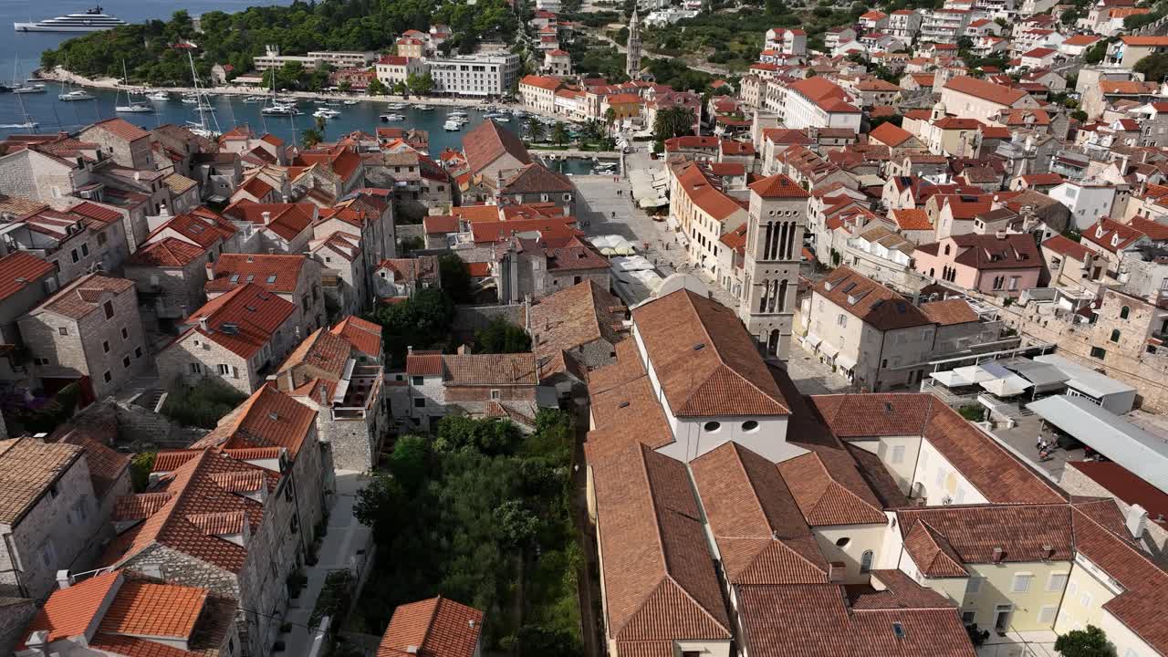 Church and old buildings by Adriatic Sea in Hvar, Croatia, aerial pull-out