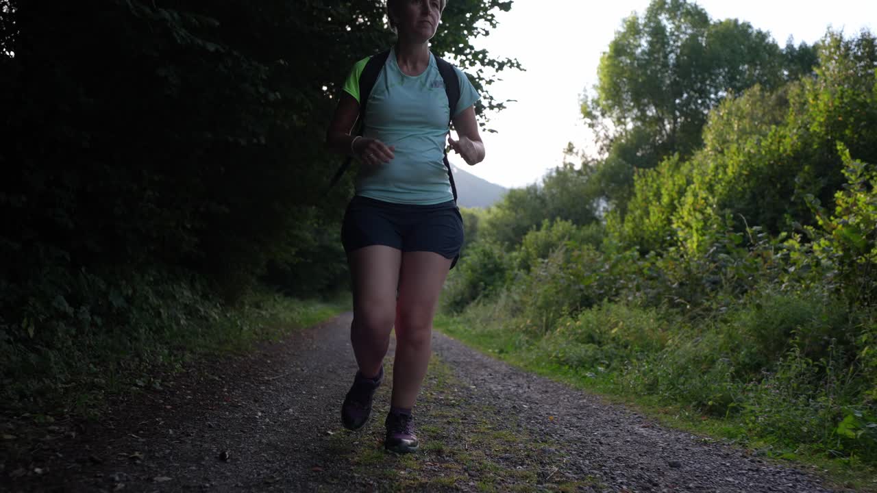 Frau, die auf einem Waldweg läuft