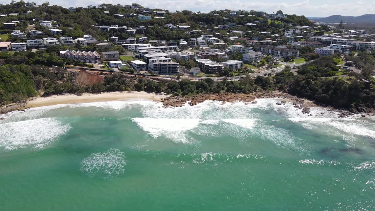 Drone aerial moving down towards Coolum Beach in Australia on a sunny day