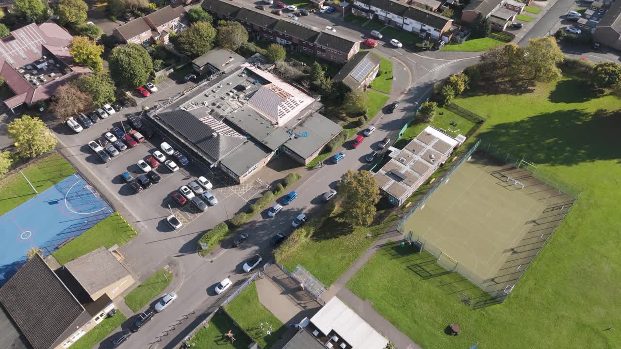 Orbital aerial view of Burnham Medical Centre surrounded by parking and green spaces, emphasizing its community setting, Slough, Berkshire UK, October 2024