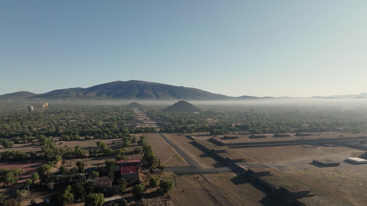 Ripresa aerea di Teotihuacan, la città degli dei, piramidi azteche, mongolfiere sullo sfondo, Messico