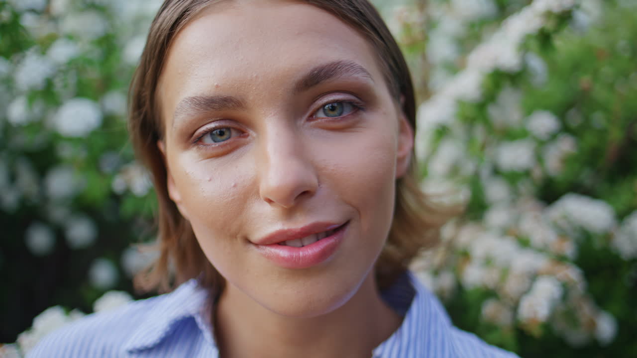 Radiant woman smiling camera in floral garden closeup. Portrait girl