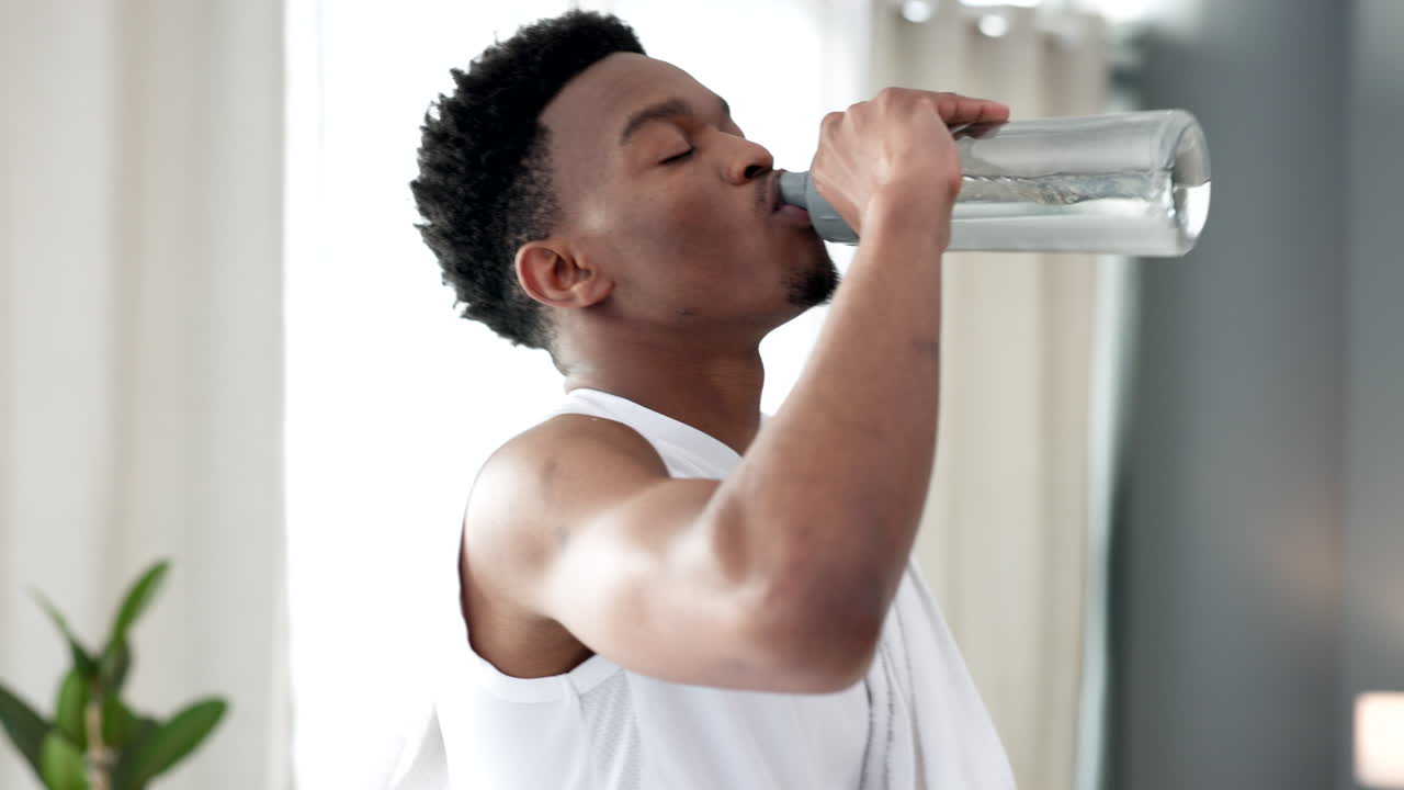 Homme buvant de l'eau d'une bouteille après une séance de sport