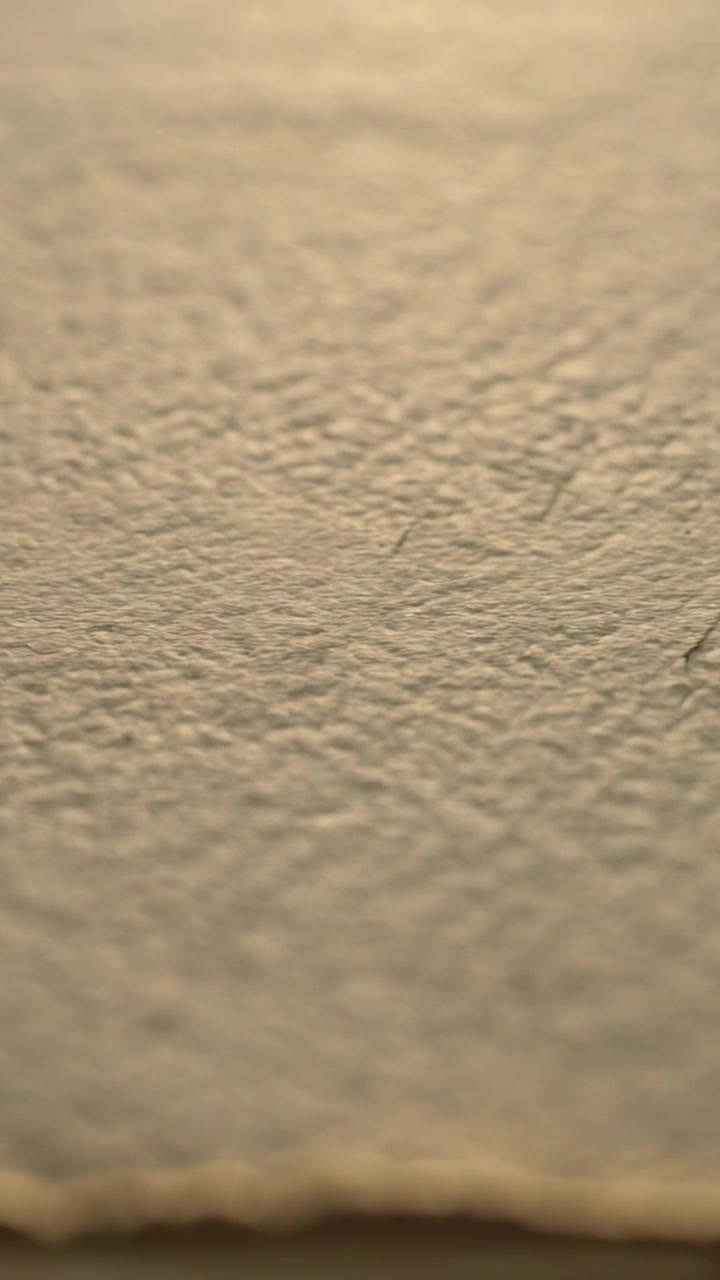 Vertical video: Focusing lens revealing painted wall wavy base indoors showing dark hairs for study