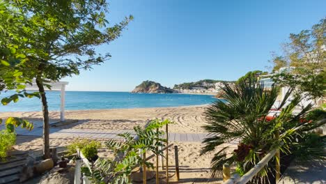 Tossa-De-Mar-Bucht-Von-Der-Burg-Bis-Zum-Strand-Mit-Grobem-Sand-Und-Türkisblauem-Meerwasser-Altes-Ummauertes-Mittelalterliches-Dorf-Fischerdorf-Mittelmeer-Zu-Fuß-Entlang-Der-Promenade