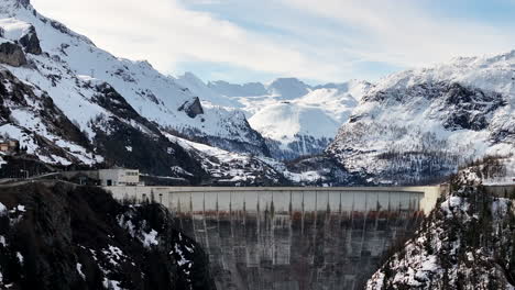 Aerial-Raising-Over-Dam-Chevril-Lake-Tignes-Savoie-France-Winter-Snow-Mountains-Alpine-Landscape-Val-d'Isere