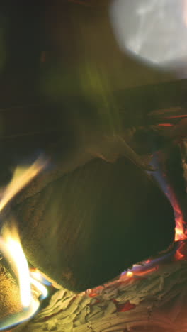 a close up of flames in log fire burning in a fireplace in vertical