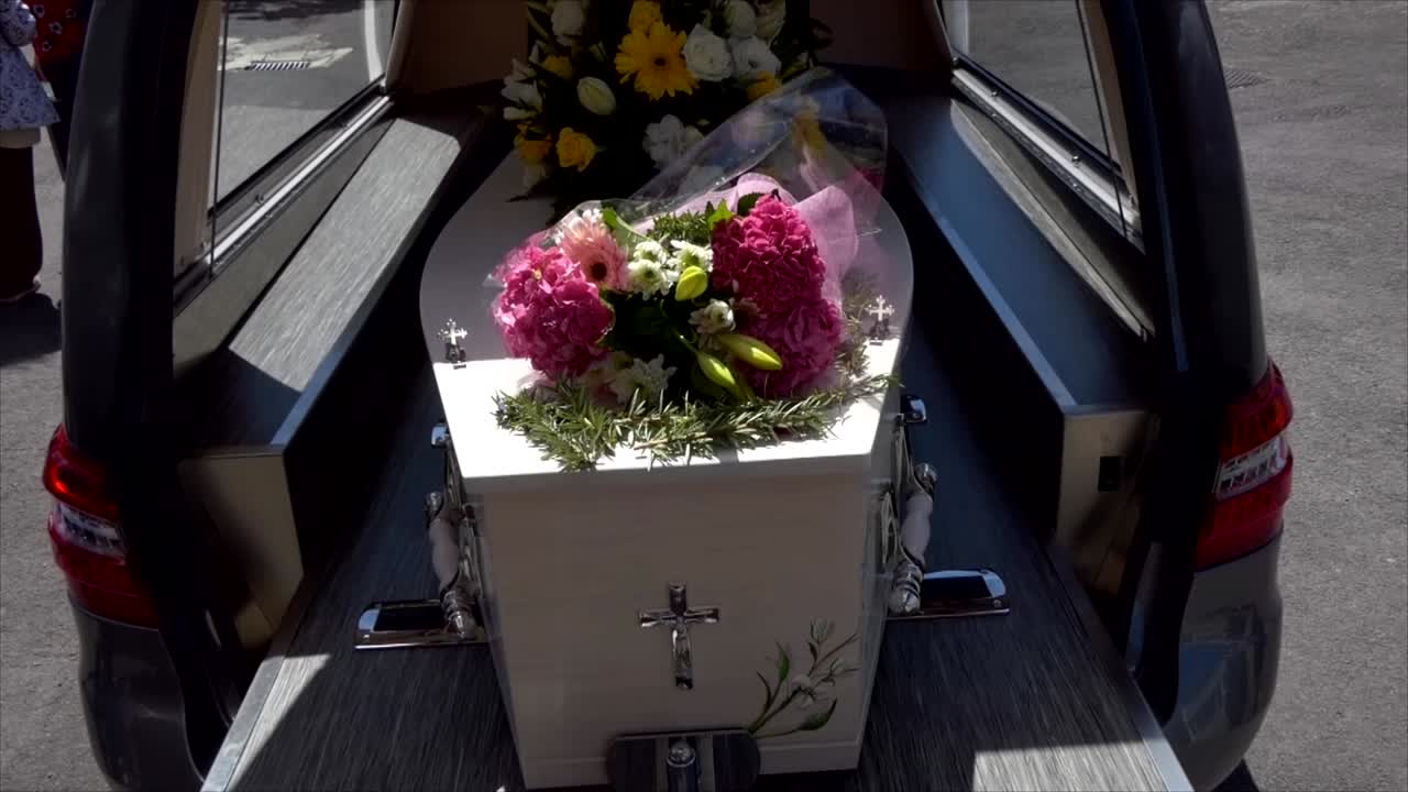 colpo del primo piano di un cofanetto funebre in un carro funebre o cappella o sepoltura al cimitero
