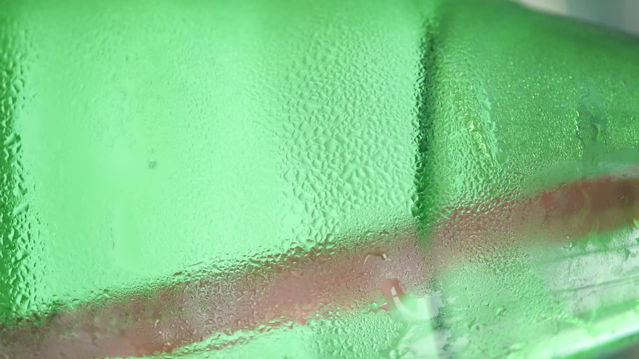 Close up of a cold green glass bottle