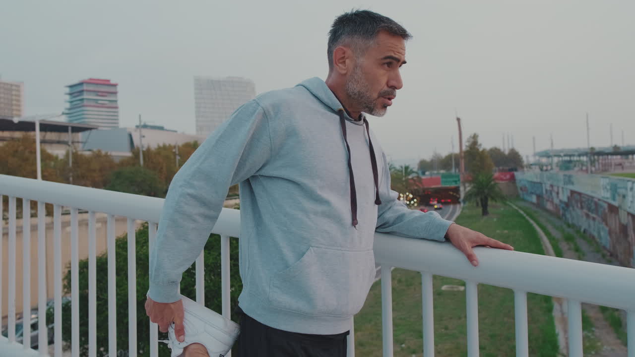 Man stretching on a bridge in the city