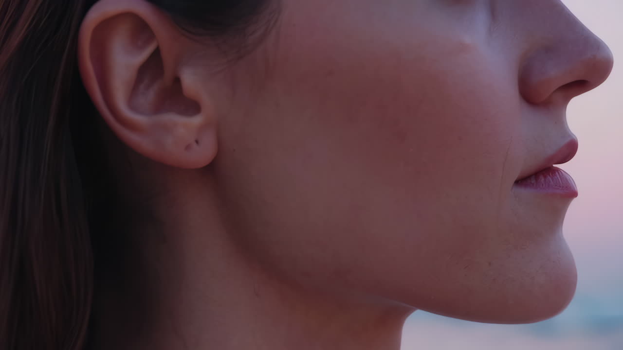 Peaceful Woman Meditating on the Beach at Sunset