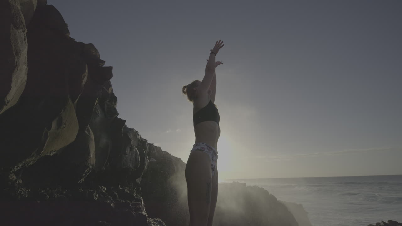 Woman on a Rocky Coastline at Sunrise/Sunset