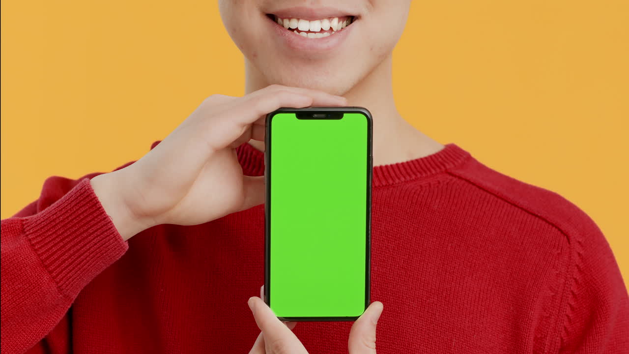 persona que sostiene un teléfono inteligente con pantalla verde